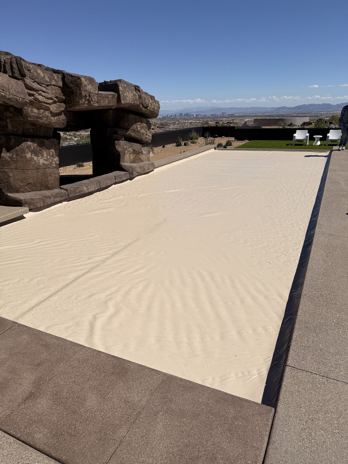 Automatic safety cover closed over a long pool with a view of the Las Vegas valley